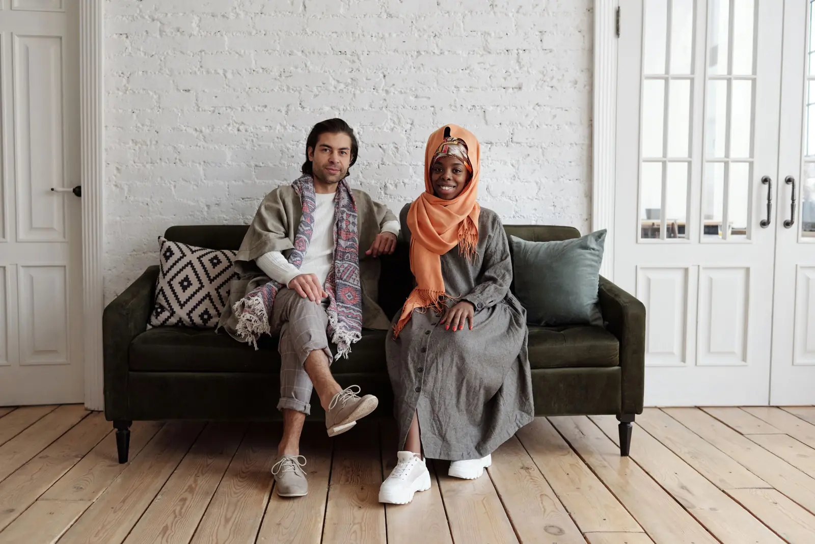 A smiling couple sitting together on a sofa at home