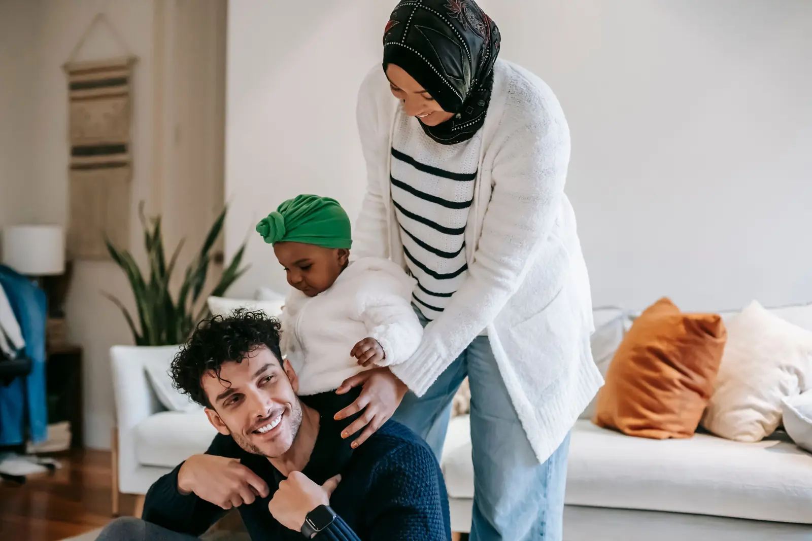 Parents playing with their young child on the living room floor