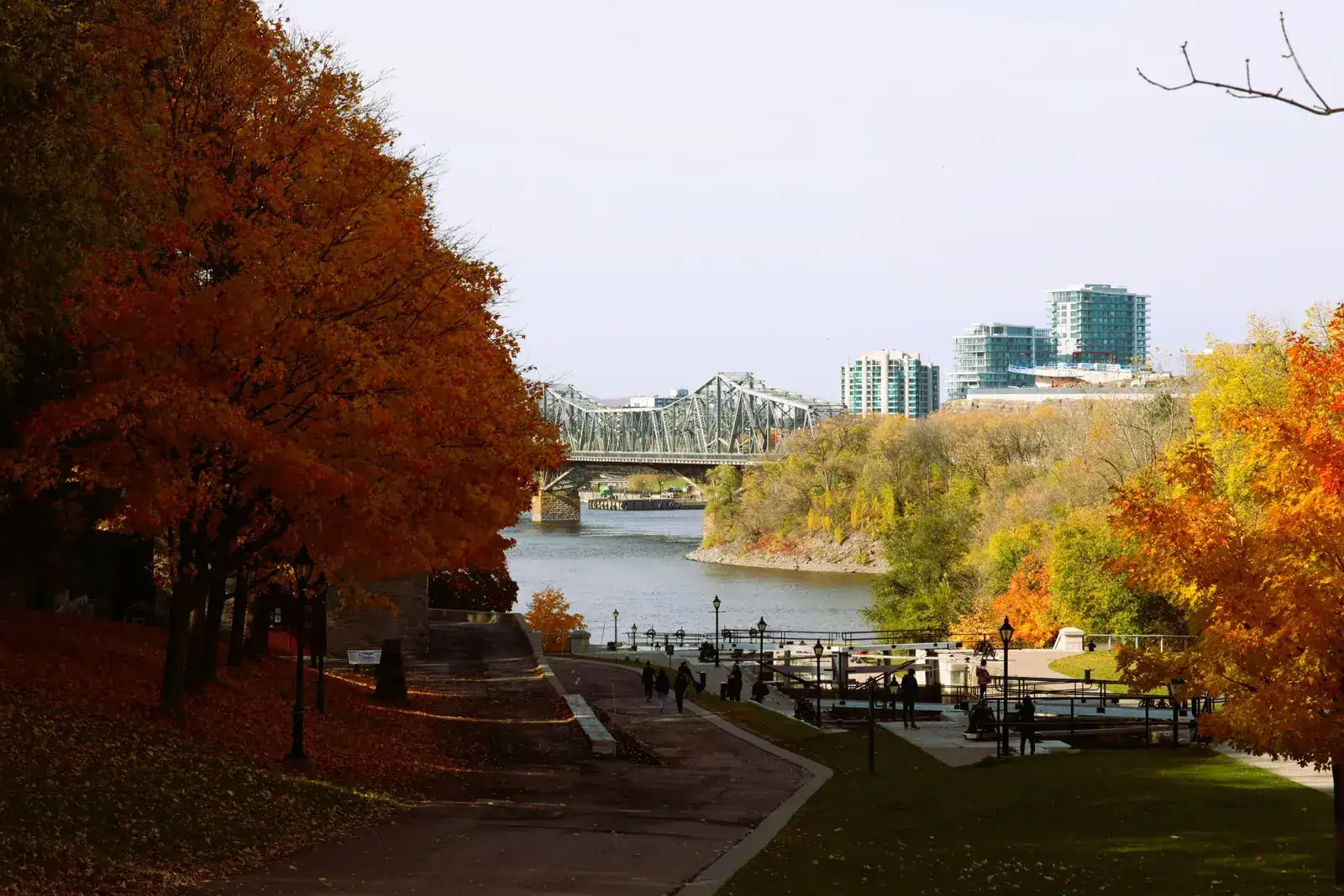 The Rideau Canal locks in Ottawa in autumn, with red maples and the Alexandra Bridge